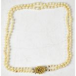 A twin strand well matched size pearl necklace with 9ct gold floral clasp set with central amethyst