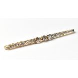 A yellow metal and diamond bar brooch made up of approximately twenty-one brilliant cut diamonds,