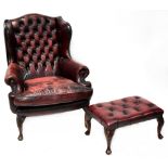 A Georgian style button back wing armchair, upholstered in oxblood leather with studs,