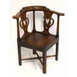 A George III oak corner chair, with two pierced splats and solid seats on moulded and chamfered