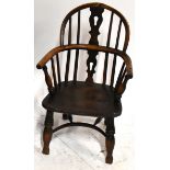 An early 19th century elm seated child's Windsor armchair with crinoline stretcher, raised on column
