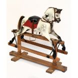 A vintage dappled grey rocking horse raised on a trestle base, length approx 115cm.