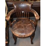 An early 20th century mahogany and leather tub elbow chair raised on cabriole front legs to pad