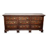 An 18th century oak Lancashire type chest with an arrangement of nine drawers, raised on ogee