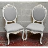 A set of six white painted French inspired dining chairs with padded back, stuff-over seats and knee