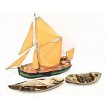 A model of a single masted sailing boat 'Kitty', together with two model rowing boats, the tallest