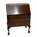 An early 20th century walnut bureau, the fall front enclosing pigeon holes and two drawers, above