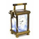 A late 19th/early 20th century brass eight day carriage clock with blue and white enamelled face and
