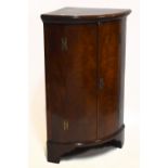 A 19th century mahogany freestanding bowfront corner cupboard, with twin panelled doors enclosing