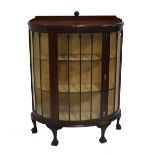 A 1930s/40s mahogany bowfronted display cabinet, the single glazed door enclosing two fixed shelves,