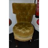 An early Victorian walnut nursing chair with upholstered back and circular seat, on scroll legs,