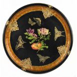 A Toleware decoupage circular tray centred with floral motifs within a butterfly and gilt heightened
