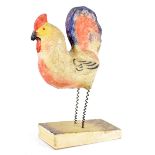 A German novelty papier-mâché toy modelled as a chicken with spring legs and squeak bellows base,