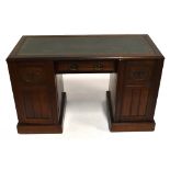 An Edwardian pedestal desk, with leather inset top above a recessed drawer and two cupboard doors,