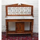 A Victorian painted pine marble topped wash stand with tile back and single panelled cupboard