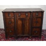 An early 19th century mahogany sideboard with central drawer above a pair of panelled doors, flanked