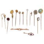 A group of predominately yellow metal stick pins, one set with turquoise, one set with a coin, one