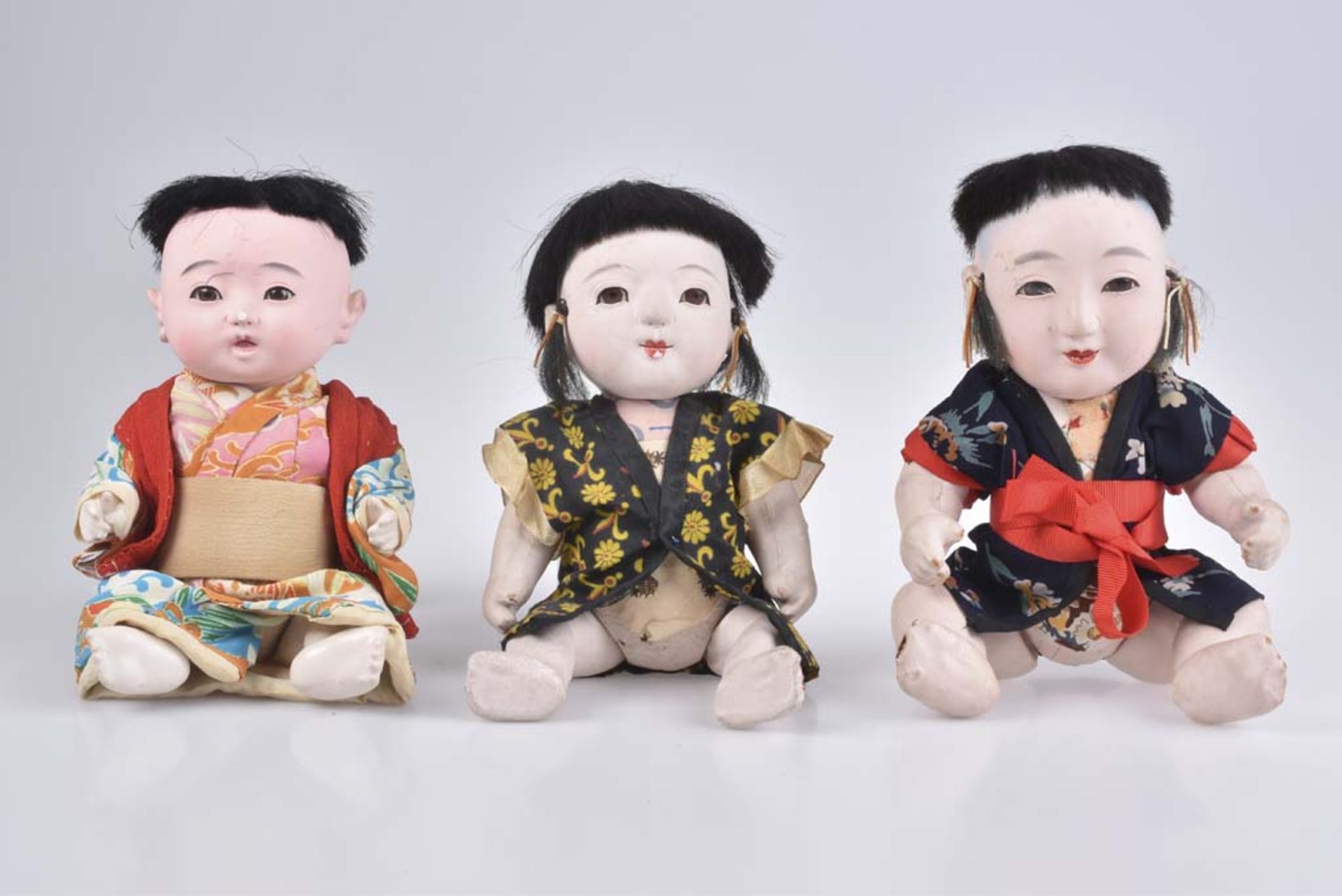 Trio sitzende Muschelkalkpuppen Japan, 20. Jh., Muschelkalkpuppe, Kopf mit Gummizug, f