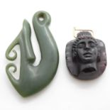 1x green stone New Zealand TIKI and 1x possibly Roman glass head pendant