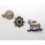 Three small silver military badges