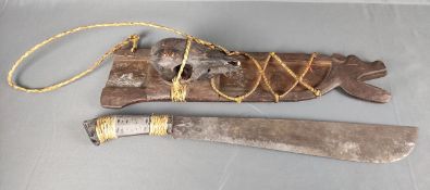 Machete, in Holzscheide mit geschnitztem Tierkopf, montierter Tierschädel, braun lackiert, Stroh ge