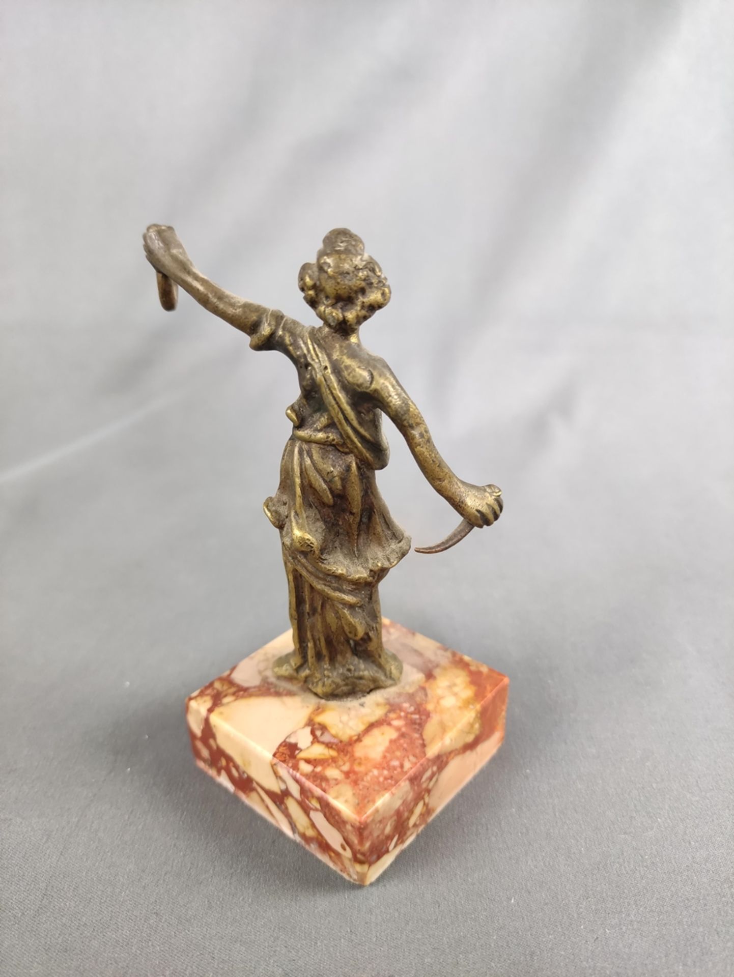 Taschenuhrenständer, Figur in Toga mit Dolch und einem Haken, auf rechteckiger Marmorbasis, Bronze, - Bild 2 aus 2