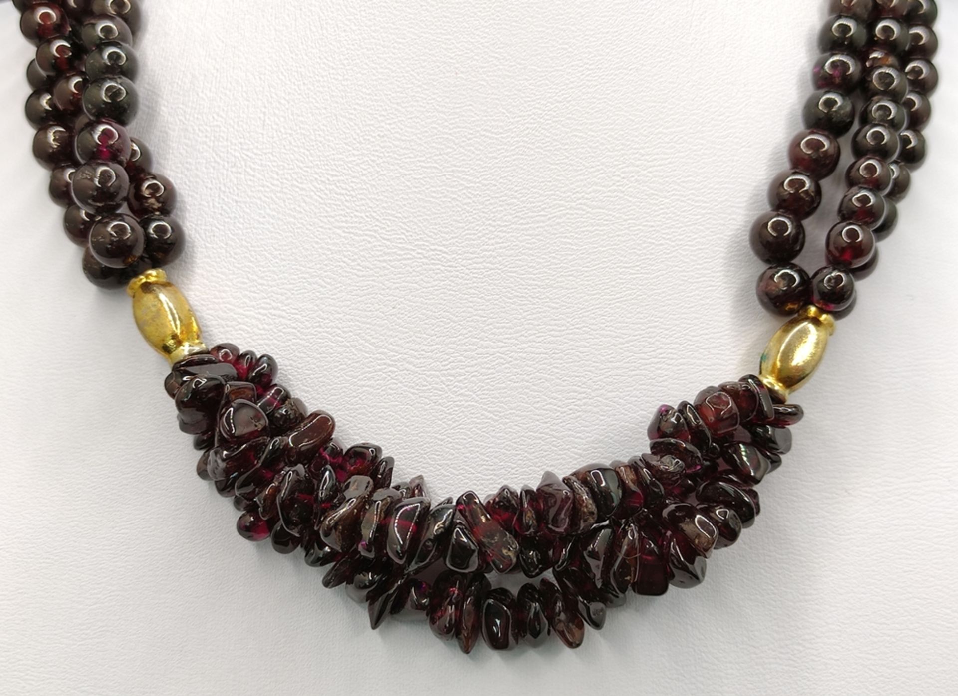 Garnet necklace, three strands, two gold plated elements in the middle, hook clasp, length 38cm