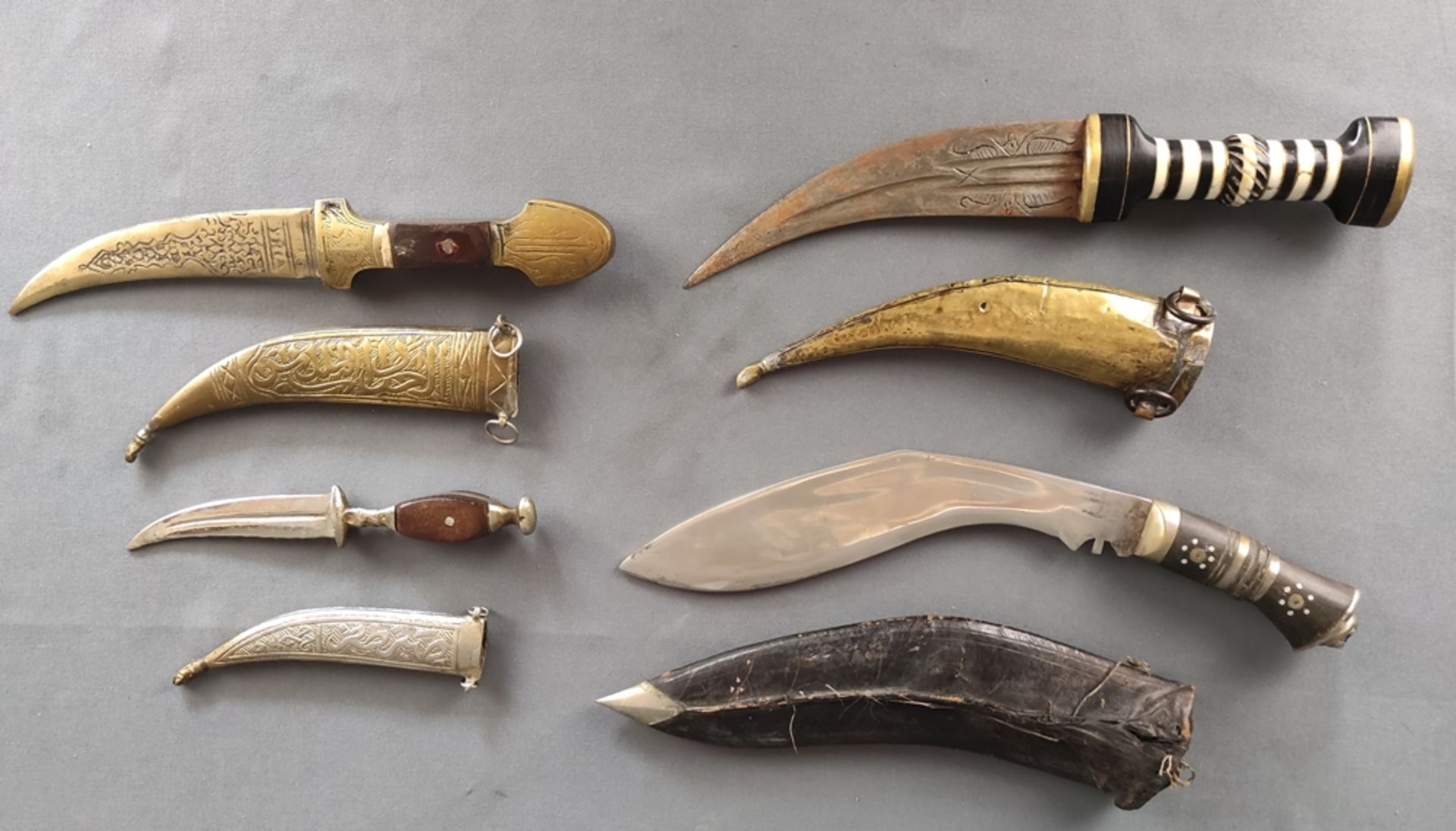 Four daggers, khukuri, curved blade, finely chased with floral decoration "India", single-edged,