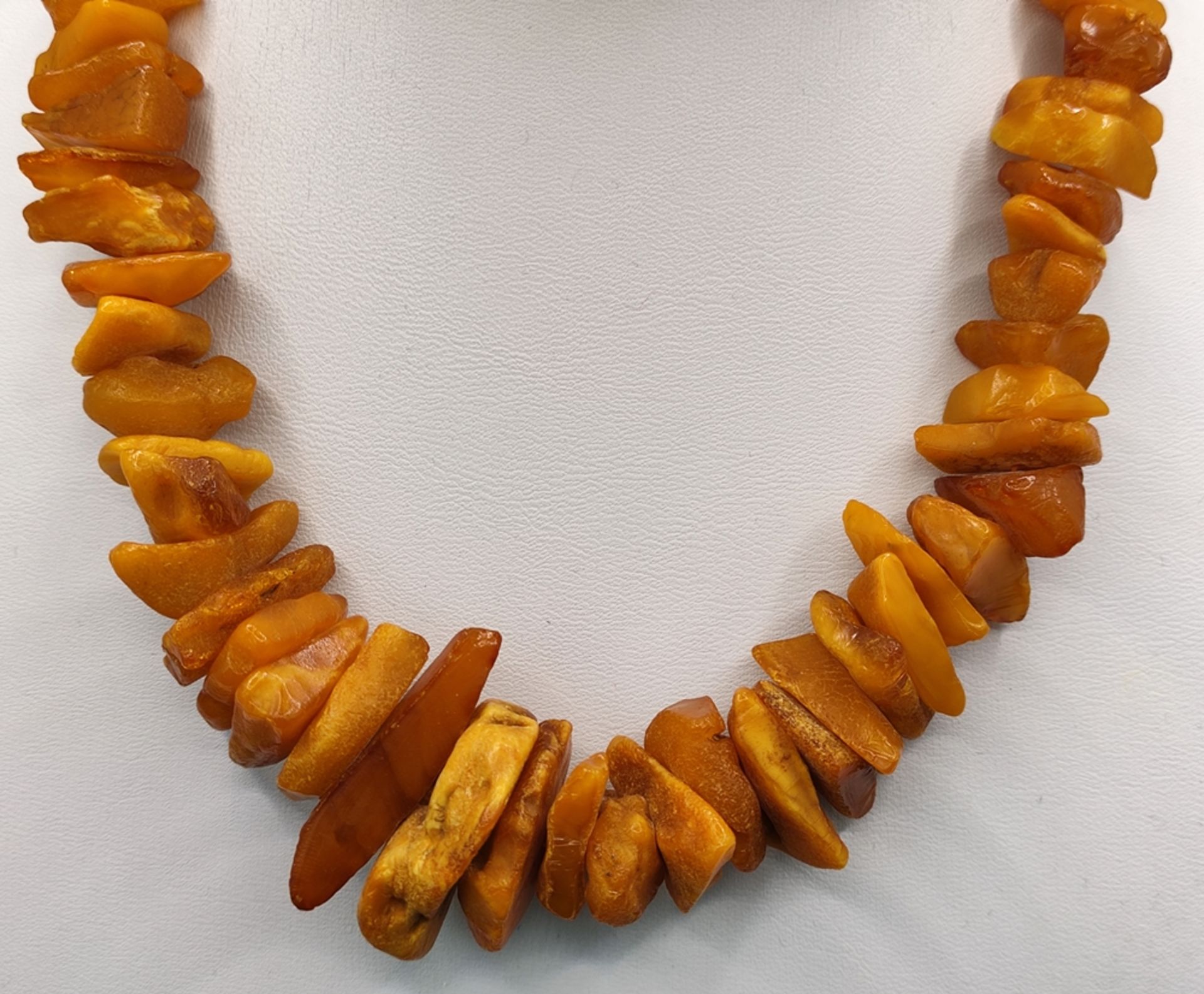 Long butterscotch amber necklace, natural amber stones increasing in size towards the center, length