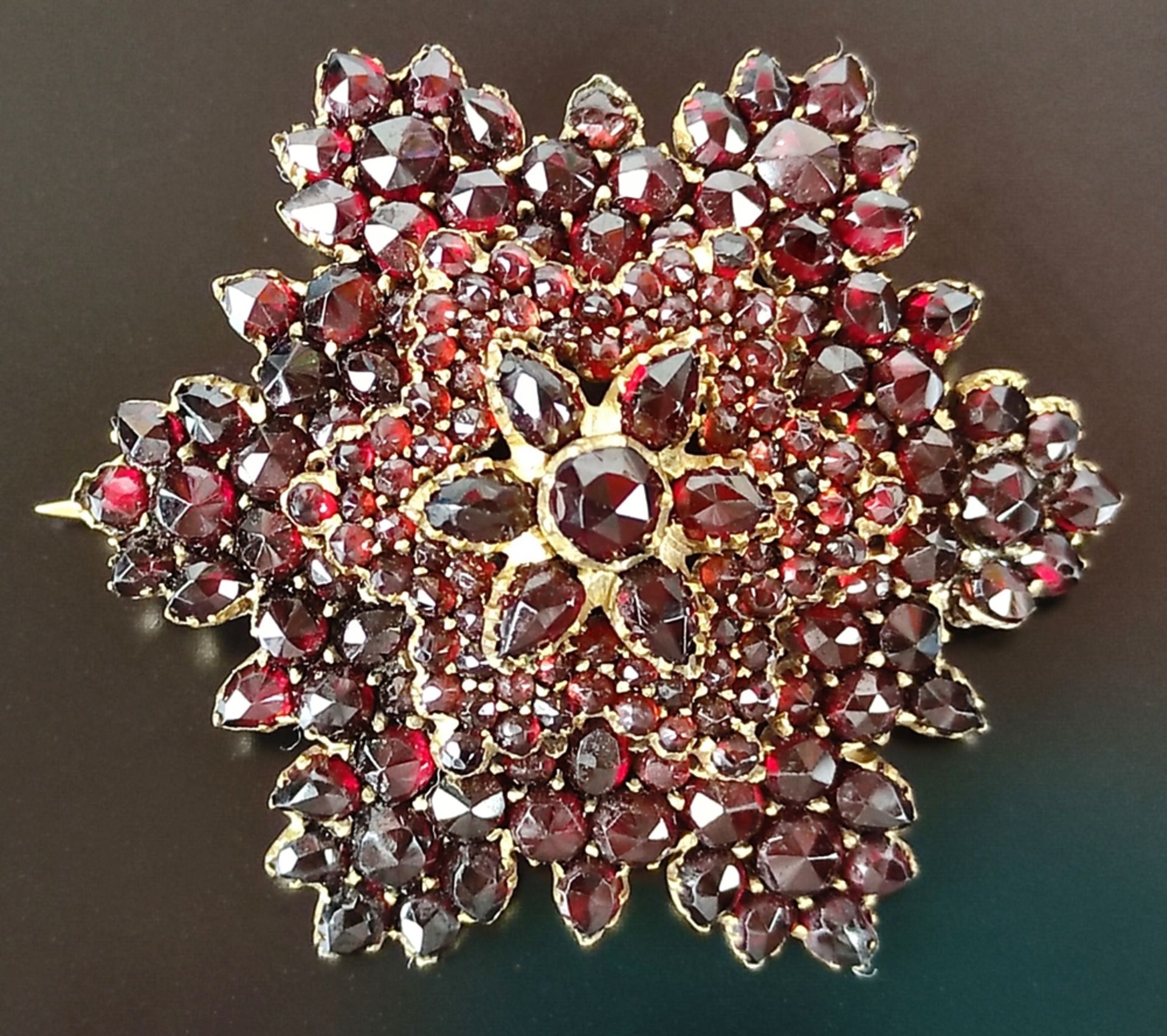 Garnet brooch, 5-tiered, set with round and oval faceted garnets, around 1900, gilded, ca. 4cm