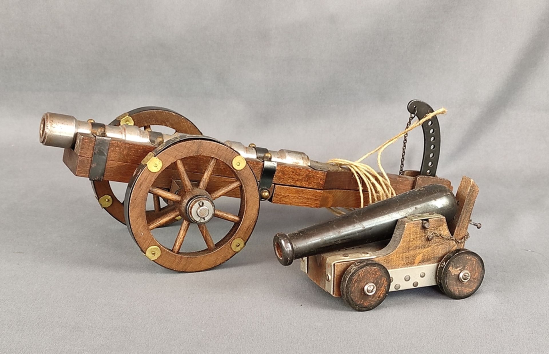 Two model cannons, iron cannon on wooden two-wheeled cart with brass fittings, cannon can be