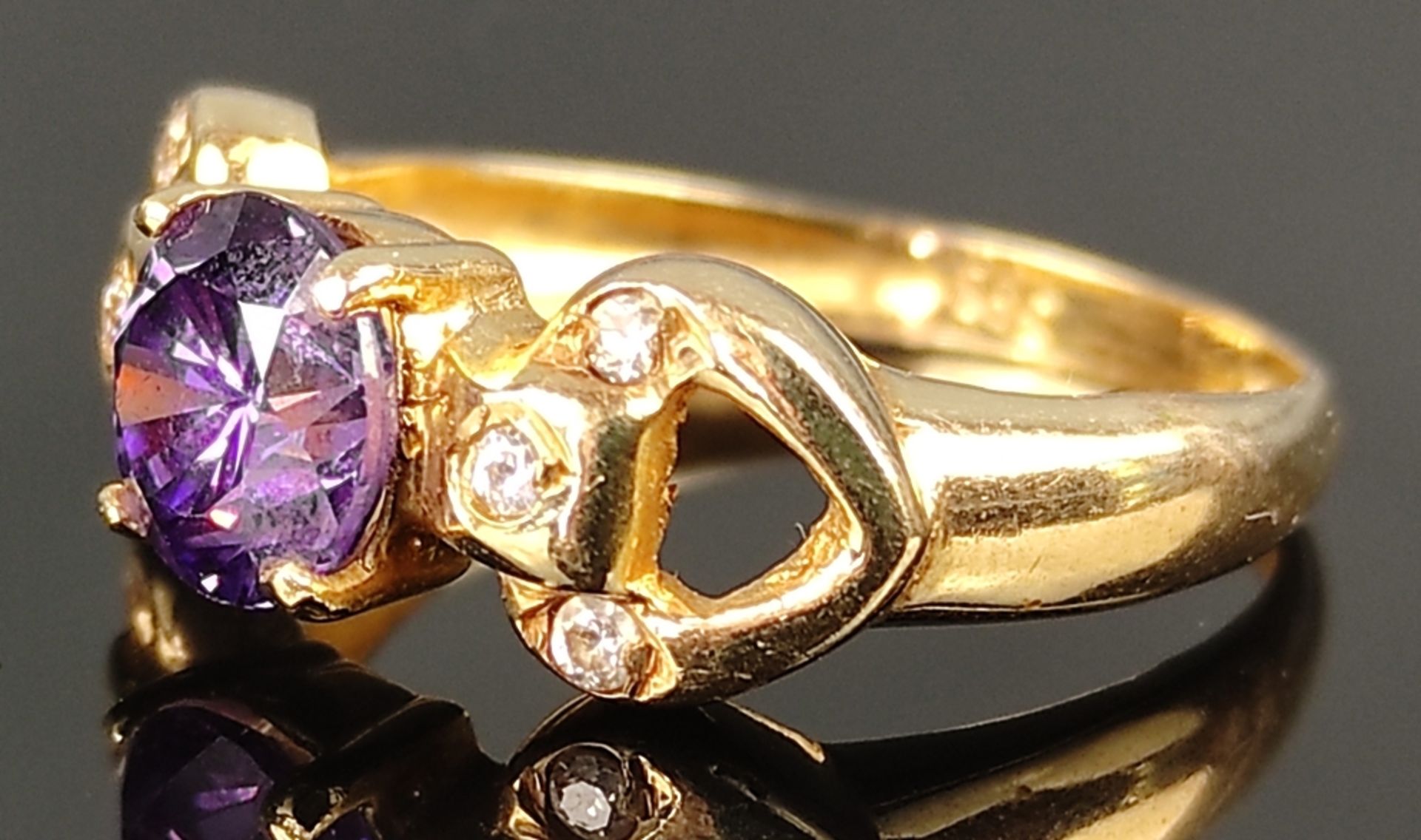 Ring with faceted purple gemstone flanked by three small zirconia each, 585/14K yellow gold, 3.2g, 