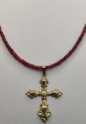 Kreuz-Anhänger an Rubinkette, reliefiertes Kreuz (4,3x3cm), 333/8K Gelbgold, an Rubin-Rondellenkett