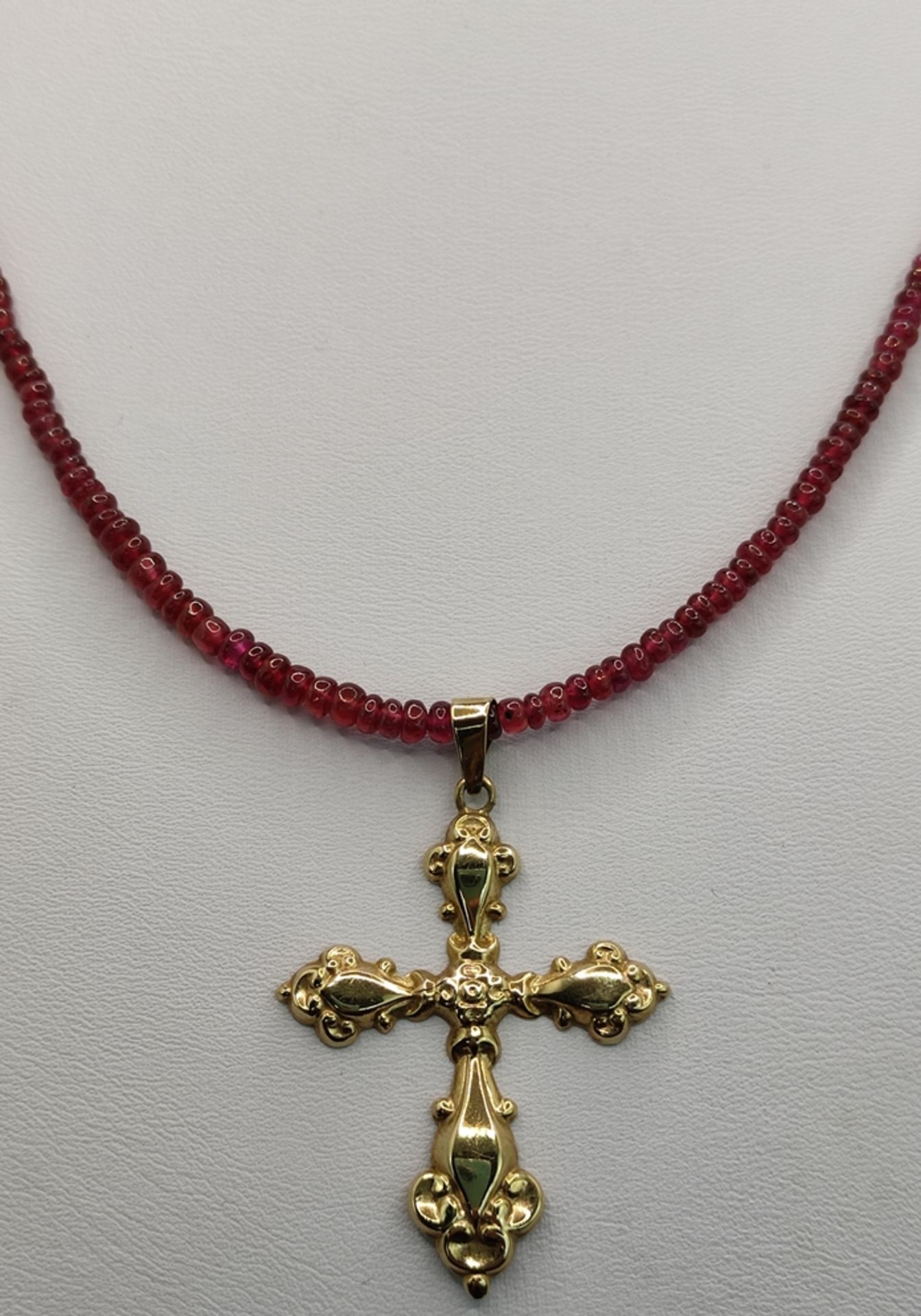 Kreuz-Anhänger an Rubinkette, reliefiertes Kreuz (4,3x3cm), 333/8K Gelbgold, an Rubin-Rondellenkett