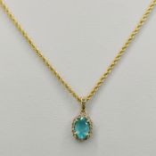 Pendant on cord chain, pendant with light blue gemstone, around it small diamonds, set in 585/14K y
