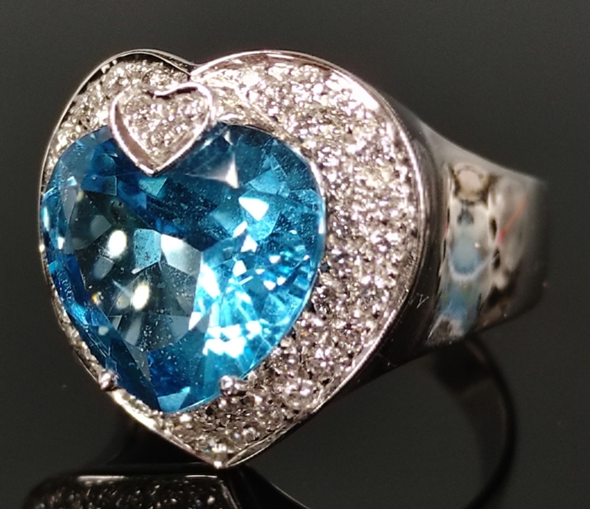 Large topaz ring, worked as a faceted heart, above it small diamond heart, around it more diamonds,