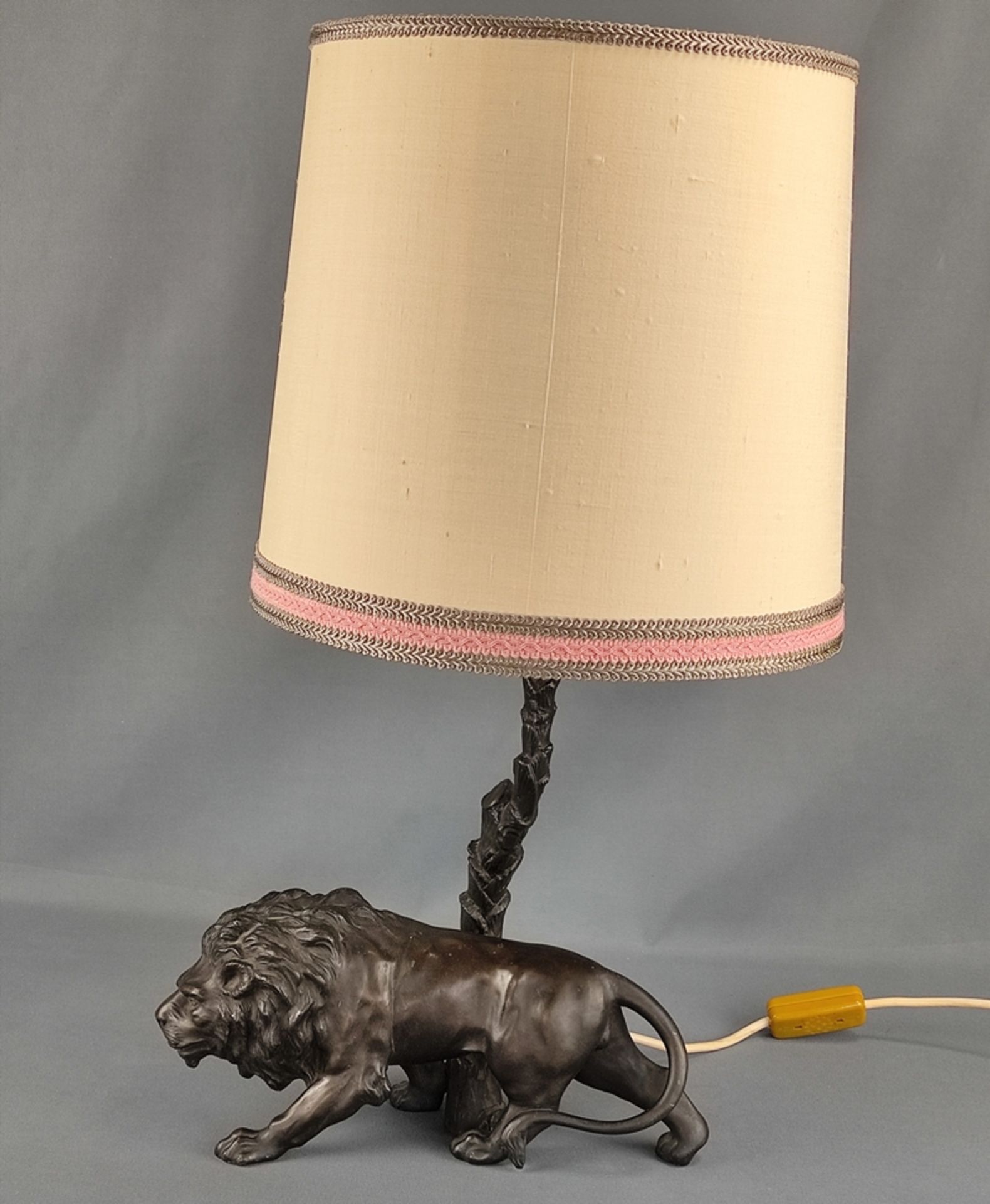 Lion table lamp, base of a sculptured lion, behind it palm tree trunk with lampshade, bronze castin