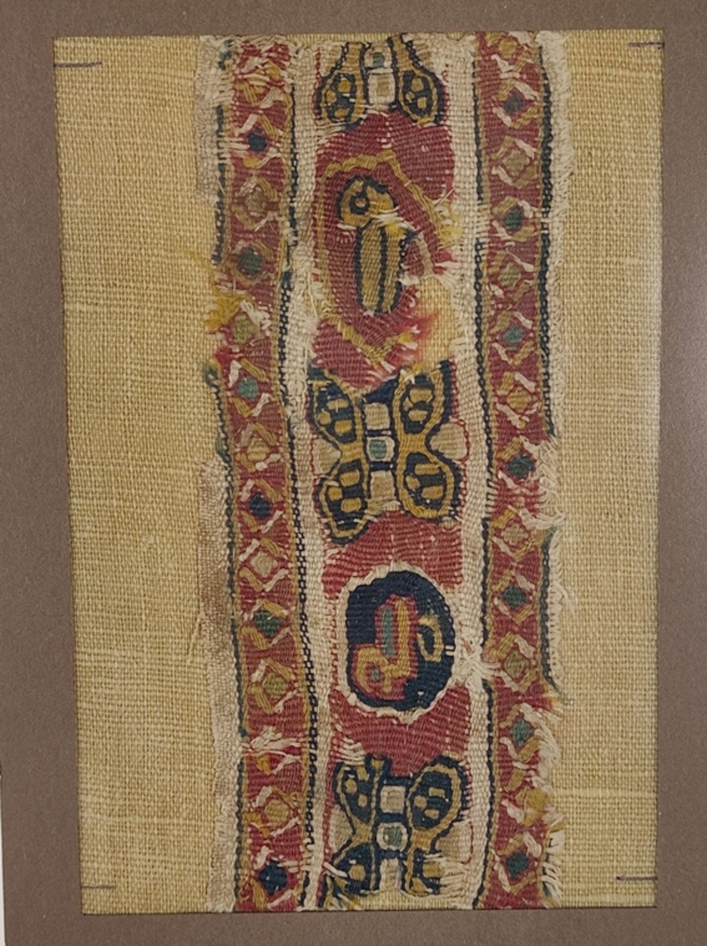 Textilfragment, koptisch, in Rahmen eingefasstes Stoffstück, 13,5x5,5cm, 30x21,5cm mit Rahmen