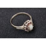 9 CT Gold Ladies Ring with an Opal Centre Stone with small red stones surrounding it, 1 missing.