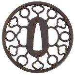 A CIRCULAR SUKASHI TSUBA, chiselled and pierced with a ring of stylised flowerheads and circles,