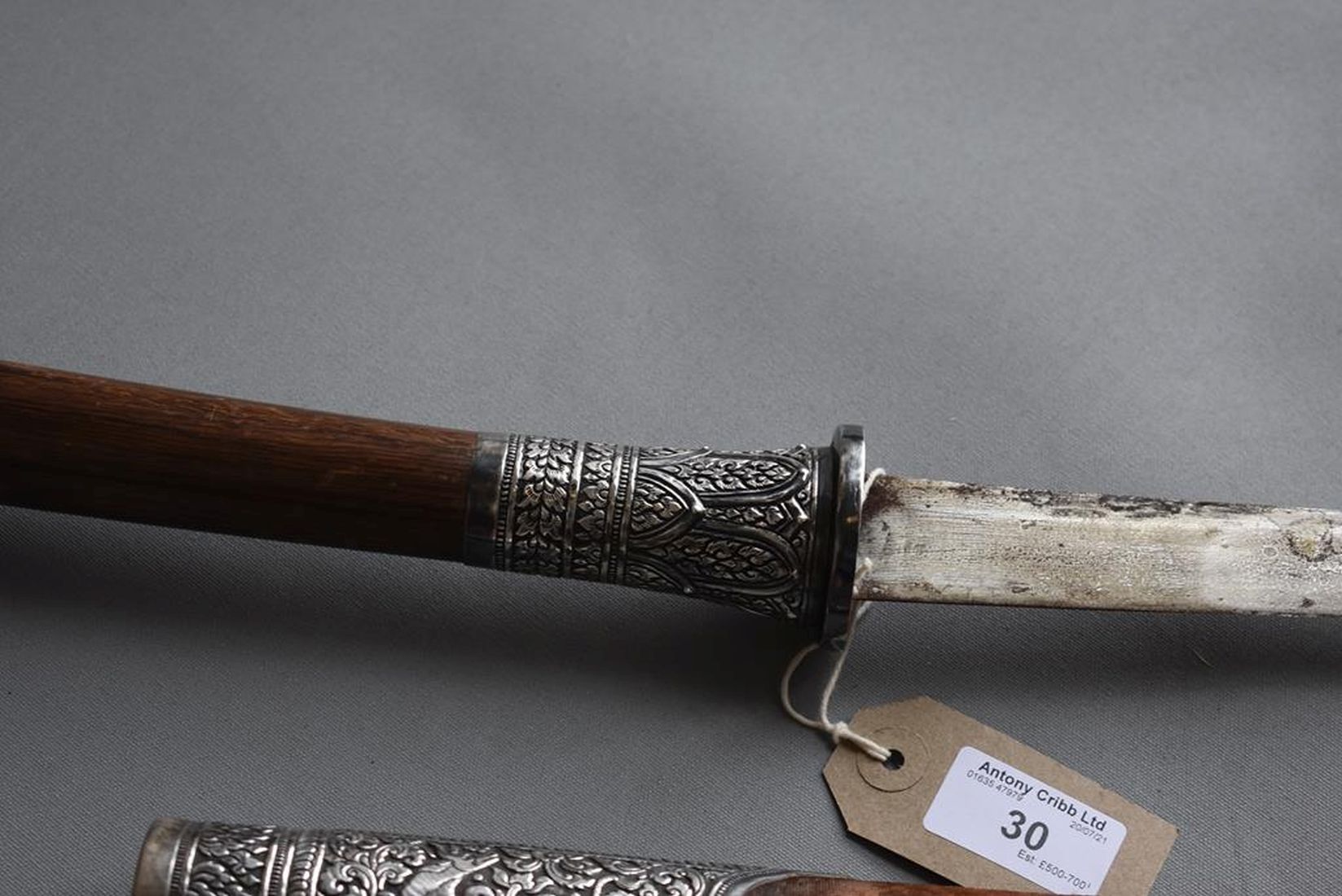 A 19TH CENTURY BURMESE DHA, 58.5cm curved blade, characteristic white metal mounted hilt decorated - Image 6 of 15