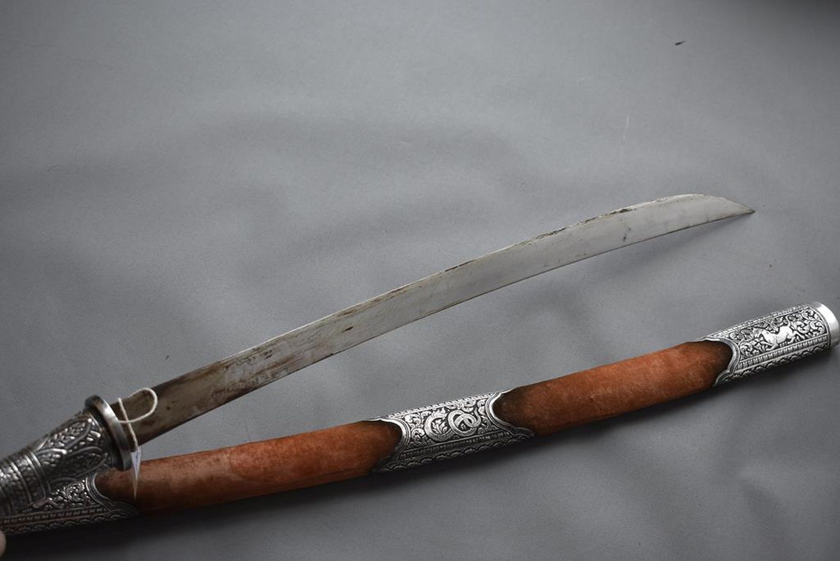 A 19TH CENTURY BURMESE DHA, 58.5cm curved blade, characteristic white metal mounted hilt decorated - Image 8 of 15