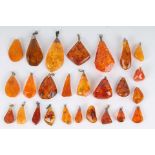 26 Bernstein Anhänger, teils mit Silber, 26 amber pendants, partly in silver,