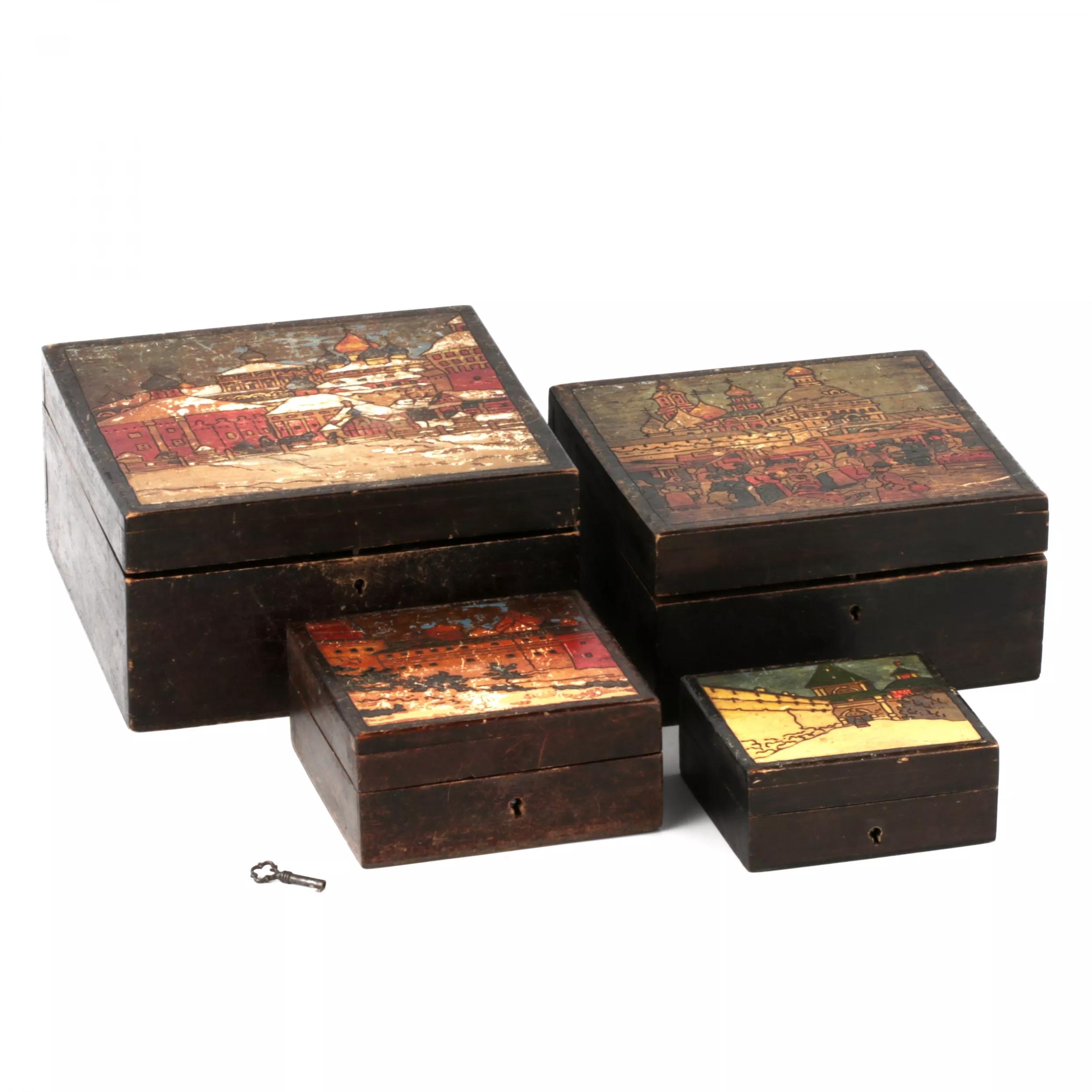 A set of four painted wooden boxes.