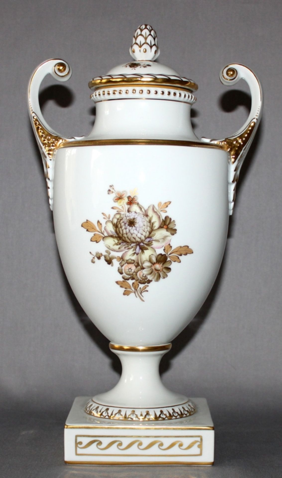 Porzellan. Fürstenberg. Kleine amphorenartige Vase mit Deckel. Mit zwei Blumenmedaillon und zwei