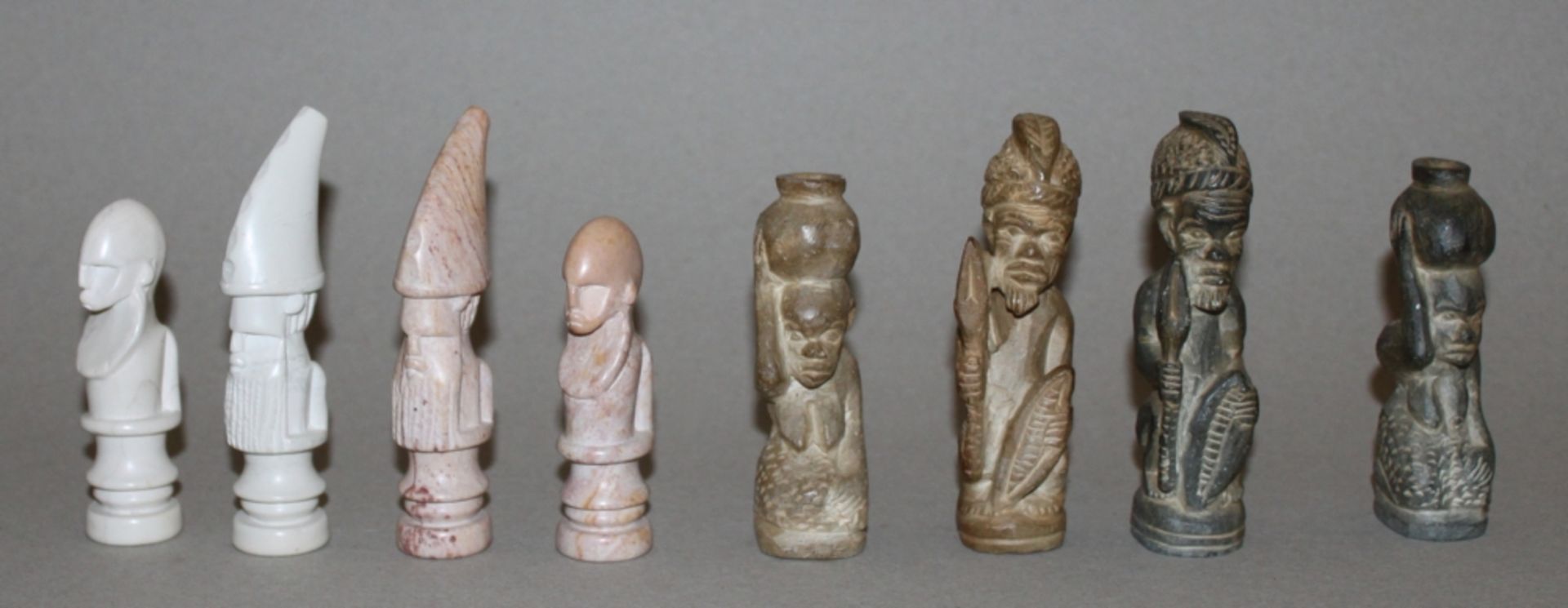 Afrika. Schachfiguren aus Kunststein im traditionellen afrikanischen Stil mit Schachbrett. Eine
