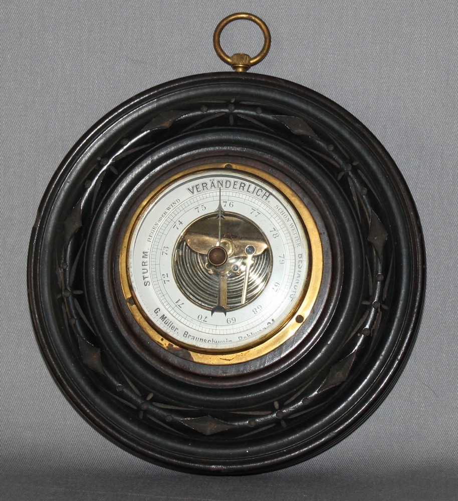 Messinstrument. Historisches rundes Barometer mit Glasabdeckung montiert in dunkelbrauner runder,