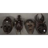 Vier Masken. Afrika. Massivholz, geschnitzt.