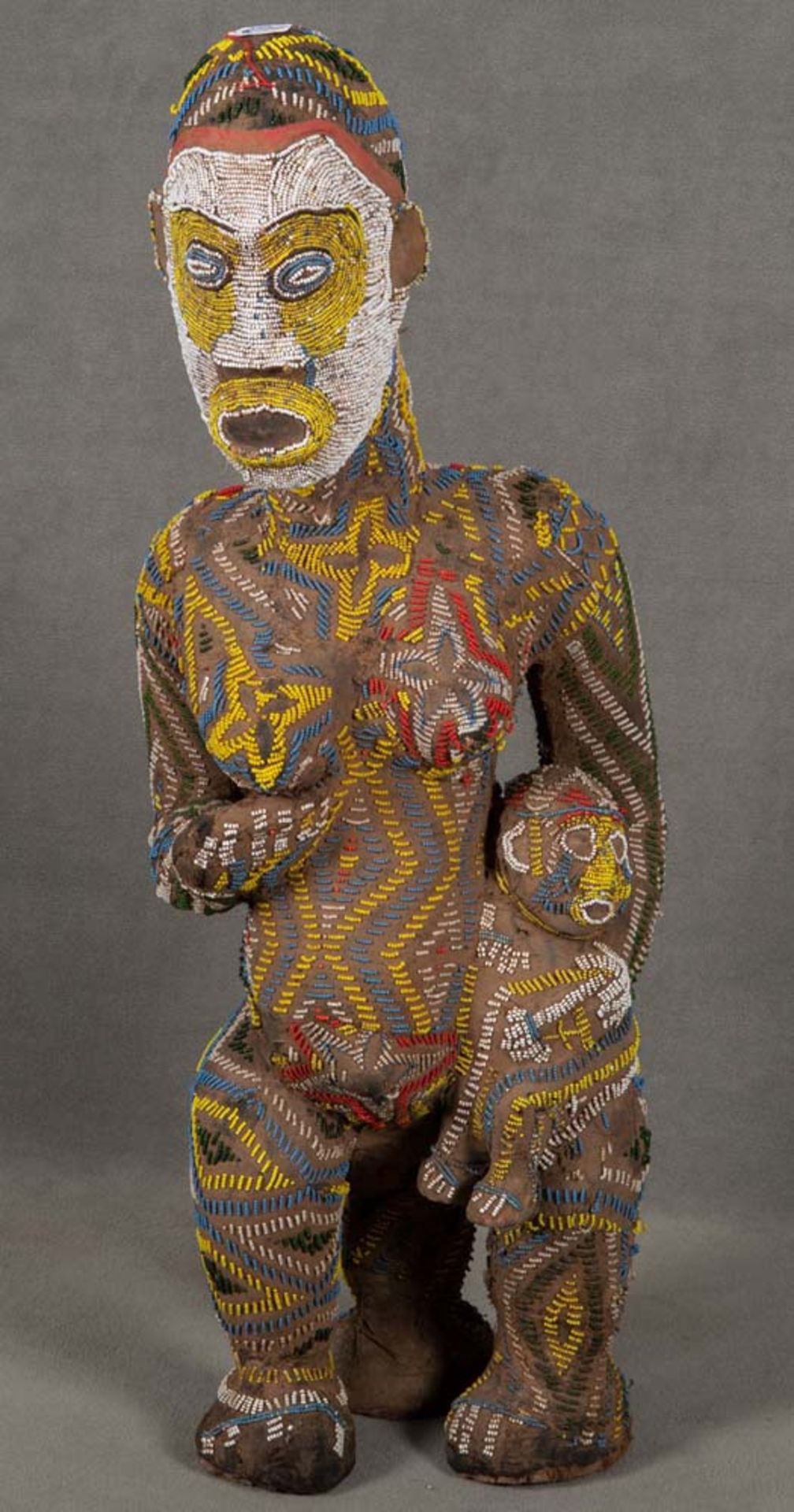 Fruchtbarkeitsfigur. Kamerun. Massivholz, geschnitzt, mit Leder- und Glasperlenapplikation, H=95 cm.