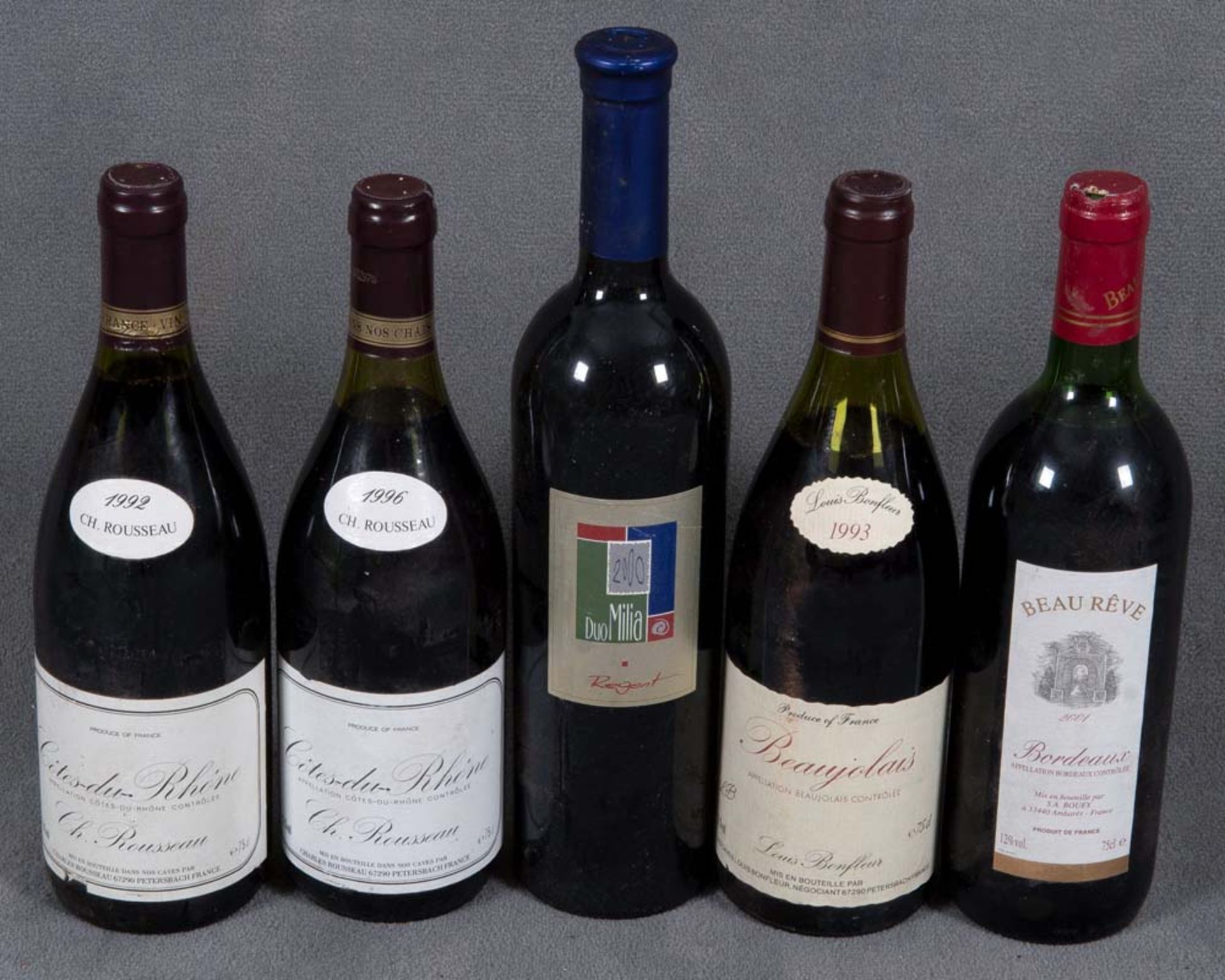 Fünf Flaschen Rotwein: zwei Fl. Côtes du Rhône 1992 und 1996, eine Fl. Duo Milia Regent 2000, eine